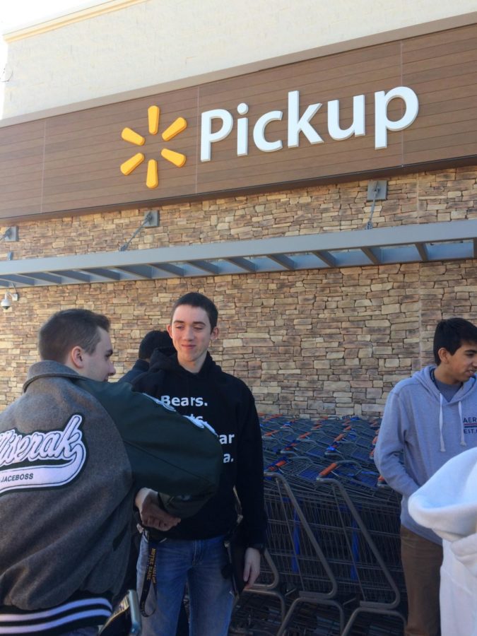 Choirs Vice President, Jace Miserak, shakes his classmates hand before heading into Walmart to perform.