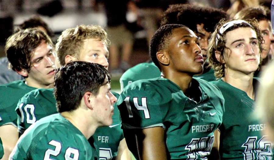 In the midst of the rest of the Eagles, Prosper players Reid Applewhite, No.  29, Lee Rowden, No. 10, Josh Graham, No. 14, and Caleb Cox, No. 10, reflect over the night as one of their coaches gives a recap after the end of the game. The boys played Eaton in this pre-season match-up. Head football coach Brandon Schmidt leads the Eagles.