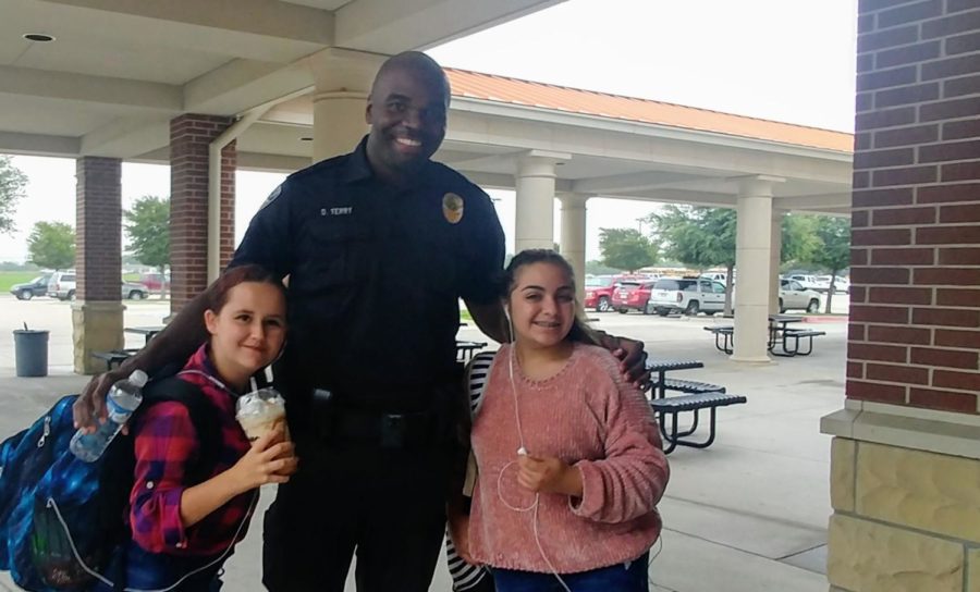 Sophomore Marissa Armont, Officer Darrell Terry and sophomore Yasmin Kazraji greet each other Wednesday, Sept. 12, at the patio entrance on the way into school.    The trio said they meet up often to talk, including how to navigate being new in a high school of more than 3,000 students. I love this place, Kazraji said.
