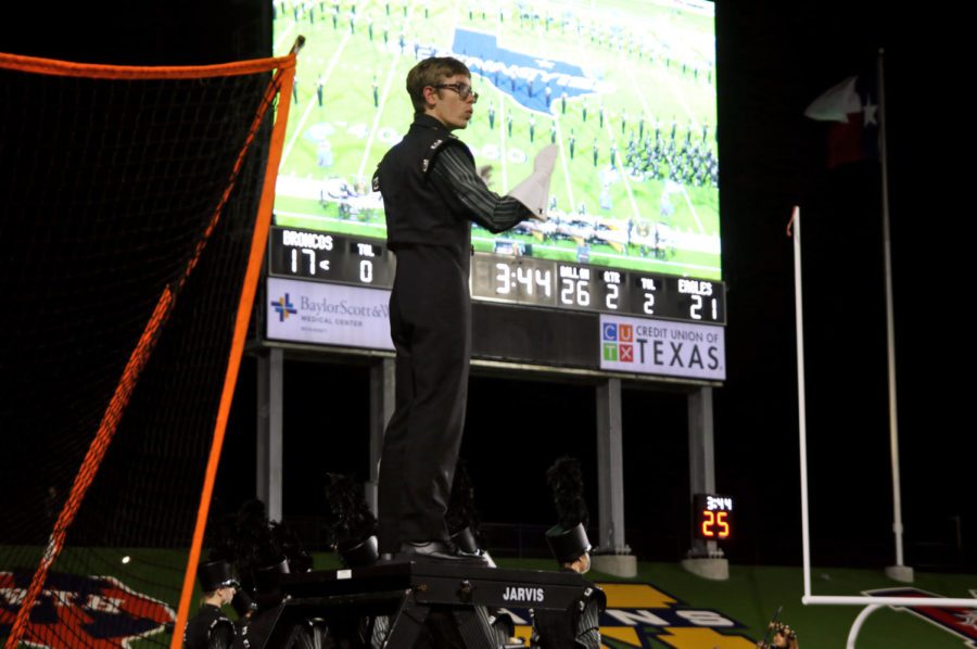 Senior William Lewis leads The Mighty Eagle Band at a football game against the McKinney Boyd Broncos on Oct. 19. His second year at Prosper, Lewis moved up to drum major this year. Drum major is the highest ranking student position in marching band. “Will is the first male drum major that we’ve had in five years,” band director John Alstrin said. “I think that’s good for the band to have both boy and girl leaders so that they learn that it’s more like a family, and we all play a part.”