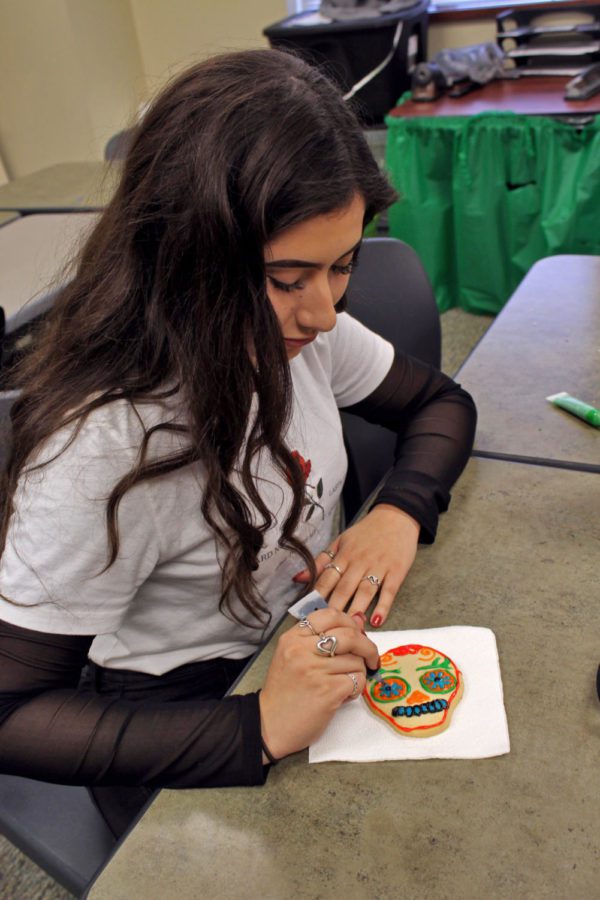 Michelle Morales decorates a cookie inspired by a traditional Mexican skull. The Hispanic community celebrated Day of the Dead Nov. 2. You come together with your family, Spanish teacher Francisco Salas said. It’s an awesome week of remembering who they were or all the good things you did together.
