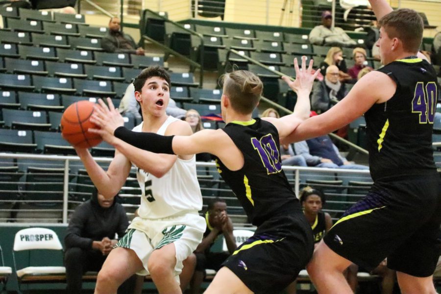 Sophomore Amman Allan, No. 5, looks to make a basket as Richardsons defender Aaaron Heft, No. 10, tries to block  him. They played Friday, Dec. 7, at home. The Eagles lost to Richardson 63-48. 
