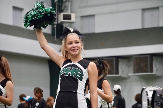 Senior and varsity cheerleader Peyton Fearin waves her pom pom. All of the Prosper cheerleading teams performed at Meet the Eagles in Aug. 2018. Prosper Cheer placed 5th at the UIL State championships Jan. 20. 