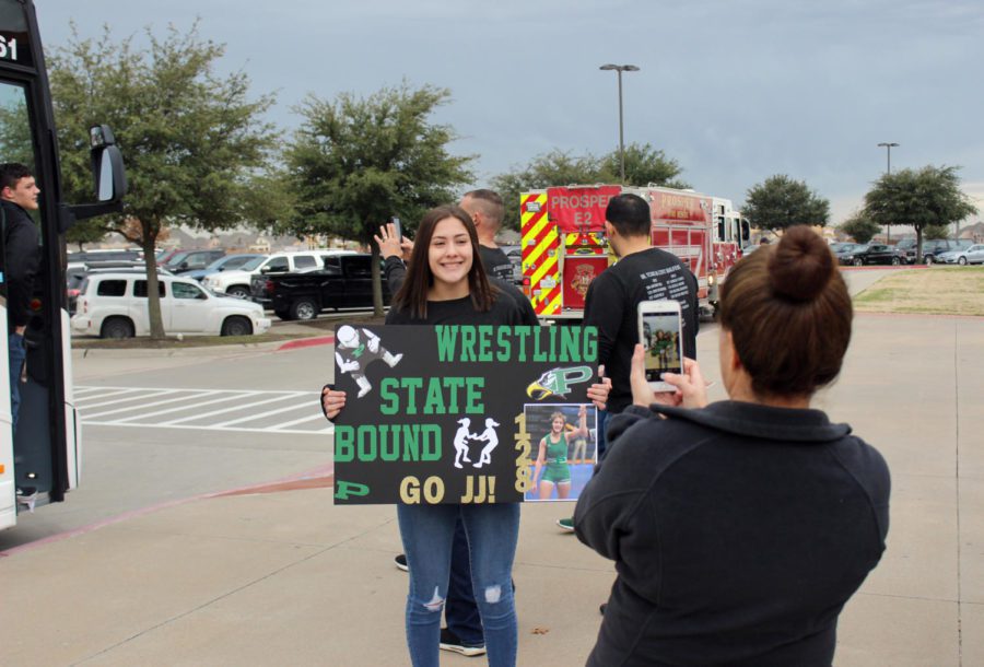 Junior Juliana (JJ) Baugher holds up a wrestling sign Friday, Feb. 22, before the team heads off to the UIL State Championship, held Saturday, Feb. 23. She placed fourth and sophomore John (LJ) Richardson placed sixth. The meet was held at the Berry Center in Cypress, Texas.