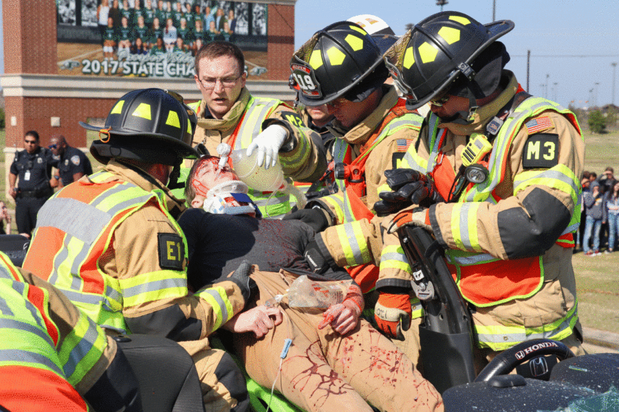 Prosper firefighters pull senior Reed Davis out of a wrecked Honda Accord March 26 during the  Shattered Dreams demonstration. Shattered Dreams is a staged event the school performs every four years before prom to educate students on the dangers of drinking and driving. Shattered Dreams consisted of students in the audio video group and the theatre department.