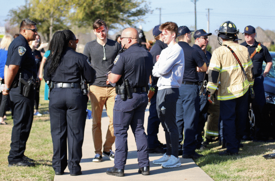 Police officers converse with actors Reid Davis, center left, and Mike Pursell, right, during the live-staged portion of Shattered Dreams March 26. Mikes so down to earth, student Zach Markey said. 