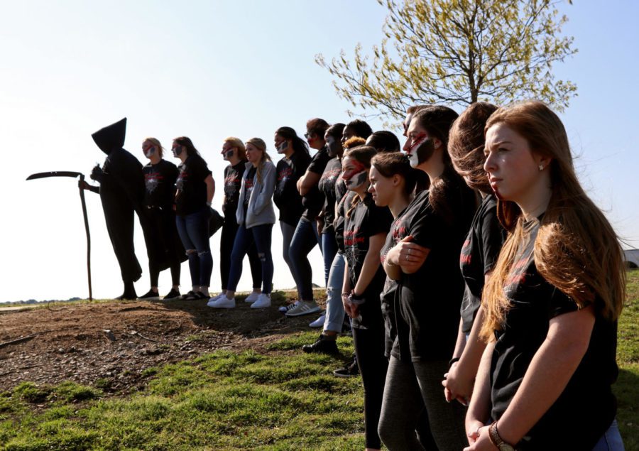 The Grim Reaper, played by senior Jeremy Muchemi, as well as students who represent the Living Dead, from the March. 26 live Shattered Dreams presentation line up near Eagle Drive, which was the site of the mock car crash. All students remained in class after first period, April 5, to watch the Eagle Production Groups film prepared for the Shattered Dreams demonstration.