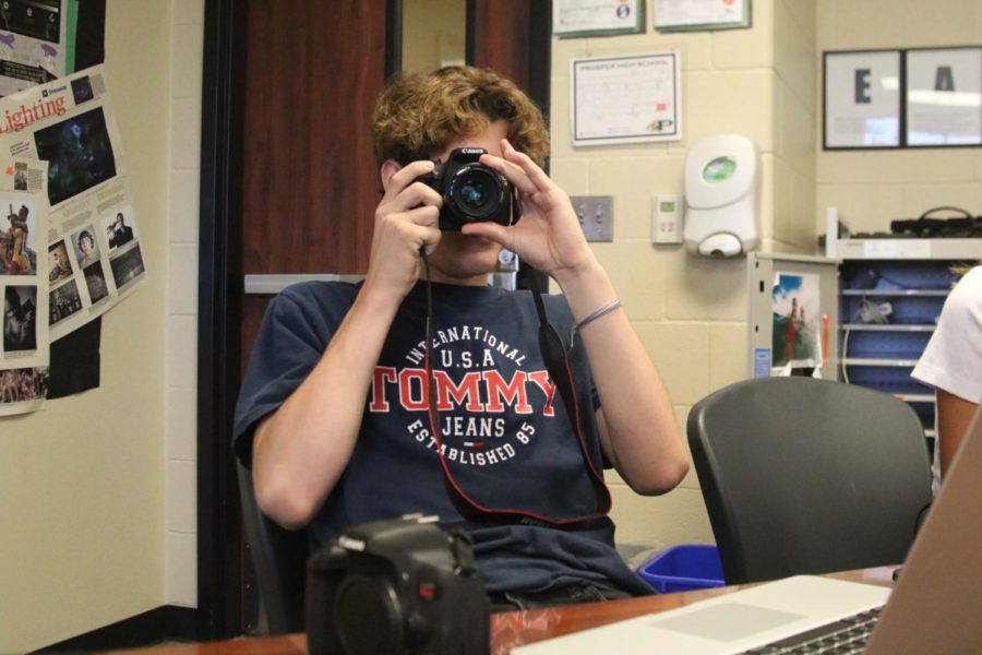 Luke McCann learns the basics of cameras in Mrs. Roskens first-period Photojournalism I class. He struggled to find a battery that fits his camera since the staff took the rest of them for an event earlier that morning. Its fun, McCann said. But, I just wish I could take photos.
