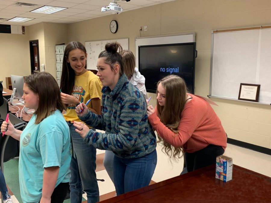 Cami Ward, Erika Barone, Haley Harig and Sadie Gonzales compliment each other during the first Make it Matter Monday in yearbook. The yearbook staff traced their hands on a piece of paper and taped it to their backs. Everyone then went around and wrote a compliment on the hand. 