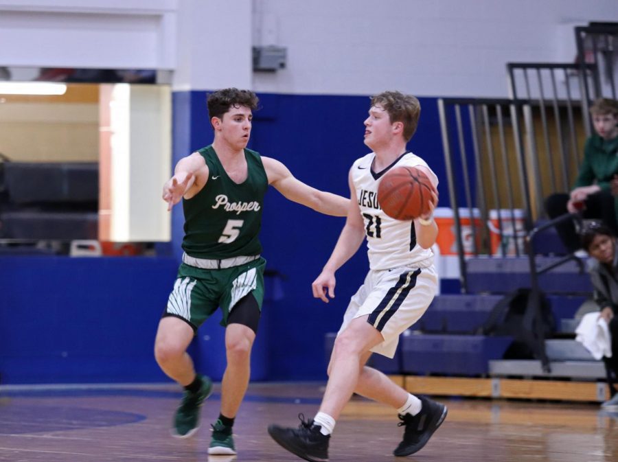 Senior Ammon Allan stays light on his feet while guarding Jesuit player Will Cordle, No. 21. The Eagles came across with a close 51-47 win over the Jesuit Rangers. Allan will return along with the rest of the varsity boys on Friday, Feb. 1 to play against the McKinney Boyd Broncos. 