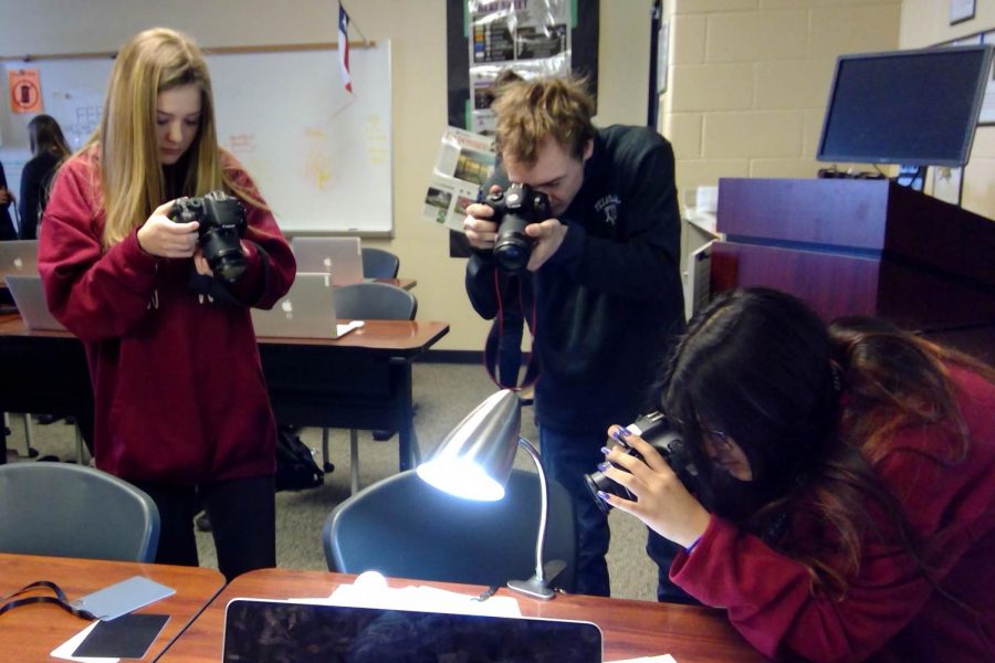 Freshman Allyson Linder, junior Hayden Turner, and sophomore Paula Noriega practice correct white balance settings on their cameras in their photojournalism class. Freshman Ethan Kern shot this photo, using equipment that allows him to click the shutter on the camera of his Microsoft Surface, which is mounted to his wheelchair. Teacher Wendy Medina helps Kern adjust the moveable arm on the chair that holds the device to position the lens exactly where Kern wants it. Then, Kern clicks the shutter when he sees what he wants in his photo. Last week, Feb. 18-Feb. 21, the class worked on taking photos in a variety of lighting situations.