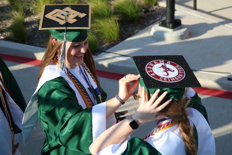Senior girls adjust their graduation caps before walking to their seats. These students spirited their future colleges with a touch of glitter. These members of the Top 10 percent of the  class of 2020 received the honor of graduating first. 