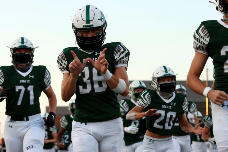 Running onto the field at the start of the game, senior Brad Larson holds up a W with his hands, predicting a win for Prosper. Larson is a senior kicker on varsity. Im proud of the way we battled back, we went down a little bit early, but the boys fought and didnt quit, principal Dr. John Burdett said. We worked for each other and thats what team is all about and thats what being Prosper proud is all about. 