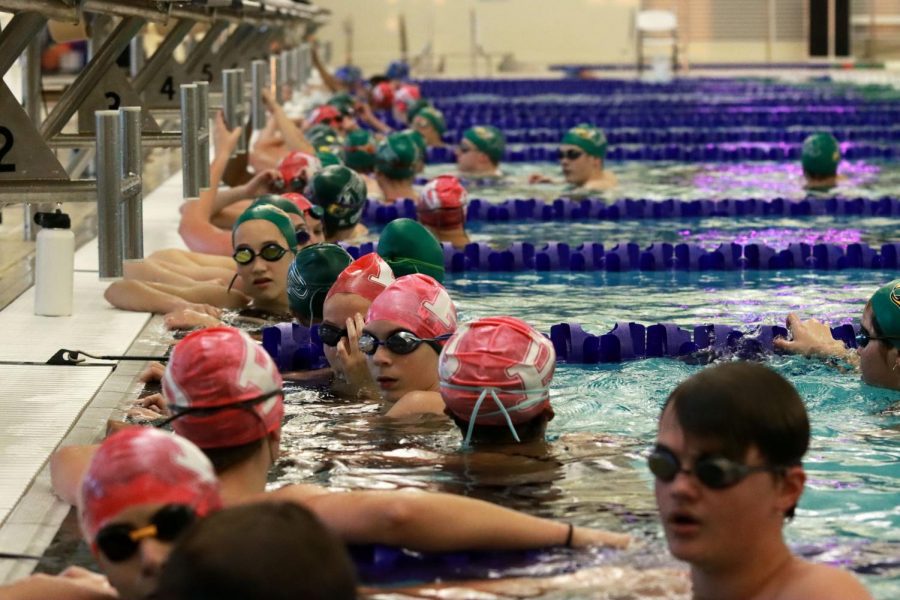 Gathered at the ends of their lanes, swimmers await warm-up instructions from their coach. Warm ups began at 6 p.m., and the meet started at 7 p.m. on Wednesday, Oct. 21. Prosper competed against Plano West High School at the meet, losing to the Plano West girls team by three points, and their boys team by 27. 