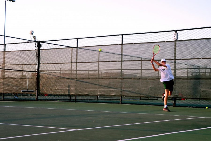 Following through on his backhand, junior Drew John returns his opponents ball. The tennis team starts their district tournament this week. They will face-off against Denton Braswell on Monday, Oct. 19 at 4:30 at the PHS courts. 