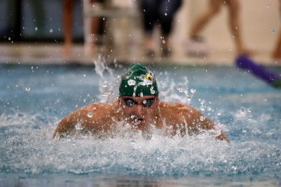 Coming out of the water for a breath, junior Scott Fredrick moves down his lane during his 100-yard butterfly event. I feel like this season will be a great one, Fredrick said. Our meets have to be smaller and masks are required, but that doesnt stop us from swimming.