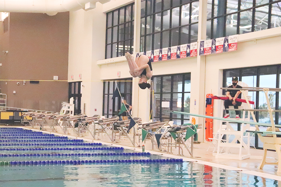 Tucking into her dive, sophomore Shaelyn Haiman spins upside down during the dive portion of the meet against Rock Hill and Friscos Memorial High. The divers competed at 5:30 p.m. while the swim teams began at 7 p.m. This marked the teams sixth meet.