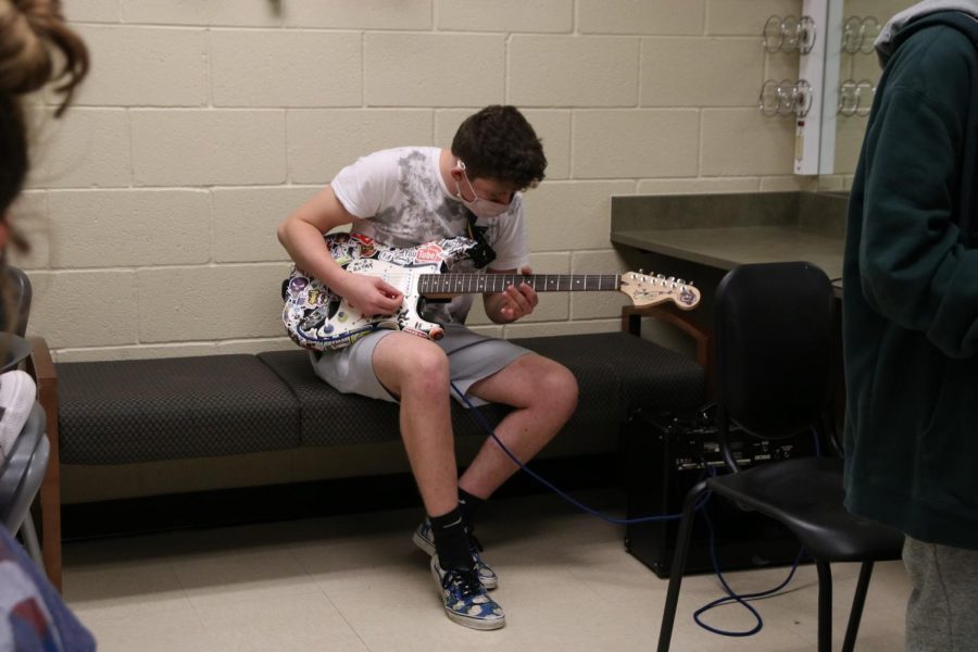 As the theatre department prepares for their upcoming winter show, senior Grayson Aron tunes his guitar. The theatre department will film their virtual December show this week. Moments to Moments is a combination of scenes, songs, and student-made poems about love, body image and mental health. The show has a gold and black color scheme to support the Hope Squad. 