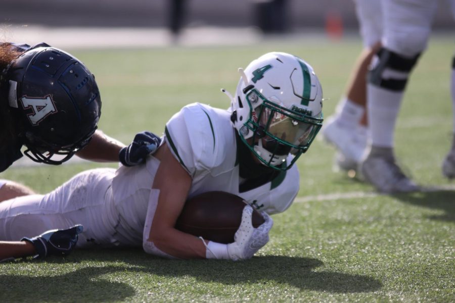 Pinned to the turf by his defender, junior Houston Hawkins keeps his grip on the football. In order to make it to this years playoffs, the varsity team will need to beat McKinney Boyd on Friday Dec. 4. Allen must win over Denton Braswell to continue into playoffs as well.  