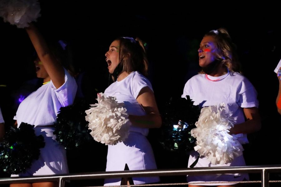 With ongoing cheers, junior cheerleaders yell in support of the football team as they walk into the arena. Cheerleaders, Talonettes and color guard members lined the walkways of the arena to cheer together. The blacklight pep rally marked the last scheduled pep rally for the regular season. 