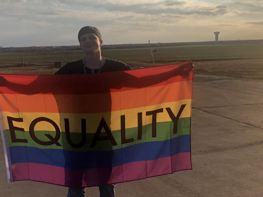 Sophomore Taylor Holcomb stands with his equality pride flag at his home. This column discusses how the media impacts LGBTQ+ viewers. LGBTQ+ representation means a lot to me, Holcomb said, Its helped me to come out and be proud of who I am. 