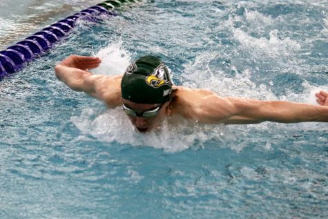 At the Jan. 13 meet, in the first lap of his 200-yard individual medley, senior Justice Hunt dives in ahead of the other swimmers. Hunt also swam the 200-yard medley relay, 100-yard freestyle, and the 200-yard freestyle relay events. He will be competing at state in the 200-yard freestyle and 100-yard freestyle.
