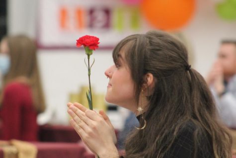 Clapping for the new inductees as she sits more than 6 feet from others, Madison Woodard holds the society flower, a red carnation. Woodard, a former member of National Art Honor Society, earned “Gold Seal” at the Texas Art Education Association Visual Arts Scholastic Event four years ago with her piece called “Sea Dragon.”  Former students, their parents, as well as district staff attended the ceremony, which carried rules designed to keep people safe from COVID-19. “I thought we were able to make it more elegant this year with the table settings,” sponsor Judy Seay said. “For me, that kind of compensated for what we missed out on as far as personal togetherness. I felt like we were able to compensate by going into slightly more elegant settings with tablecloths and centerpieces. It was more like a banquet as opposed to receptions.”