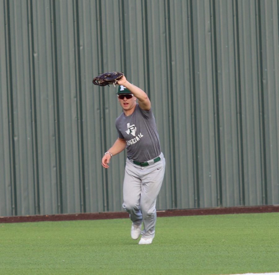 Holding his mitt in the air, junior Jacob Devenny makes a pop fly out in center field, ending the inning. Devenny announced that he will be playing for the Rice University baseball team in the fall of 2022. The next game for the team will be a home game on Feb. 13, at 11:00 a.m.
