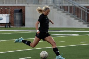 Preparing to kick the ball, senior Kaitlyn Giametta runs toward the goal. She scored the first goal of the game with an assist by Hadley Murrell. Giametta also plays club soccer for FC Dallas.