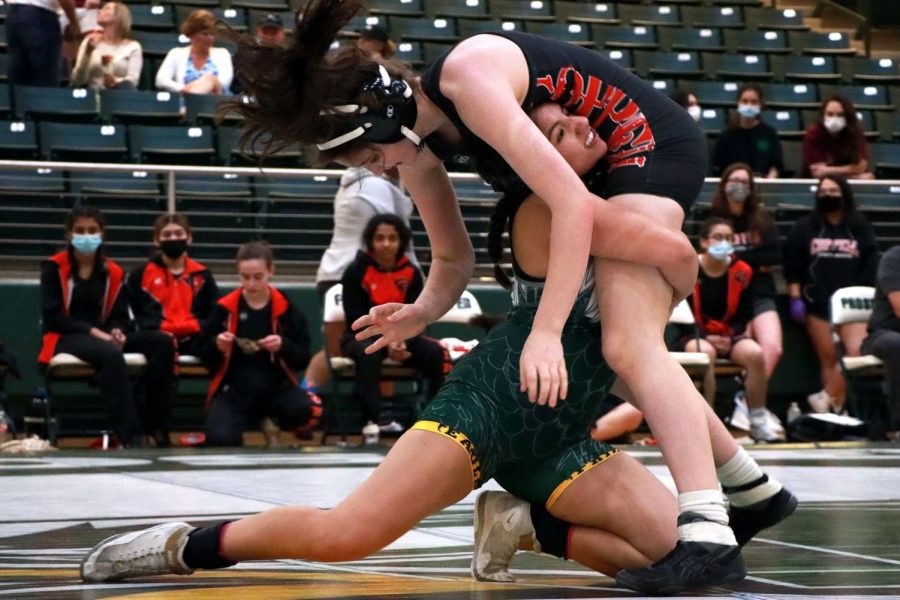 Lifting her competitor, junior Taylor Martinez works to get a takedown. Martinez has wrestled at the state championship twice in her three years on the girls varsity team. My favorite part of my match was when I was able to get a lot of points, Martinez said.