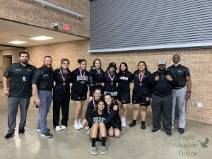 The varsity girls wrestling team gathers following their district-meet wins. The girls team had six girls place in the top three of their brackets. They will continue to the regional competition. Two girls hold the alternate spots for regionals. Allen High School hosted the district tournament  April 9-10. Pictured is Coach Frescas, Coach Cooper, Ashley Vogelpohl, Delia Luna, Meghan Flaherty, Katherine Hall-Smith, Andrea Garcia, Lauren Garst, Taylor Martinez, Ciera Stuver, Alyssa Galiendo, Coach Cabet, and Head Coach King.