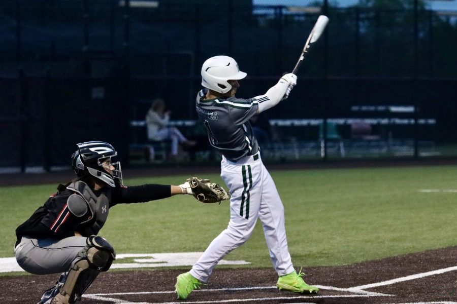 Hitting a home run, junior Jacob Devenny swings his bat in the second inning. Devenny plays both football and baseball. He is committed to Rice University to play baseball. 