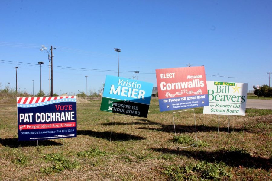 Waving in the wind, four school board election campaign signs stand on one side of Prosper High School. This year, there are five candidates running for Place 4, and two candidates running for Place 7. Early voting is held April 19-27, and is followed by election day May 1.