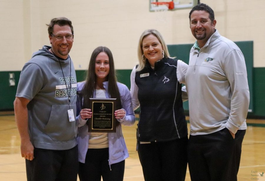 Standing with girl's basketball coach Trey Rachal, Director of Athletics Valerie Little and girl's golf coach Ryan Salinas, senior Chandler Browning accepts her 