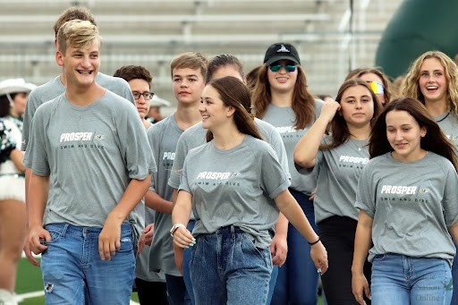 The Prosper swim and dive varsity team walk down the field at Meet the Eagles. Meet the Eagles occured on Saturday, Aug. 14. The event was to introduce fall sports in the new school year.