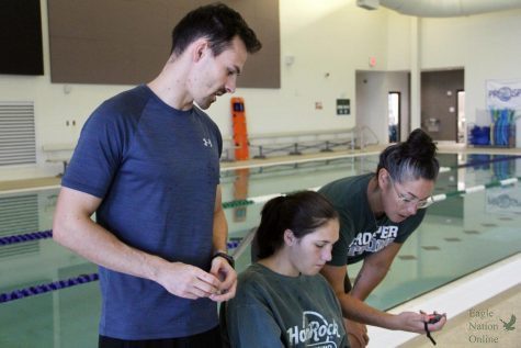 Helping his athletes log their lap time, assistant swim and dive coach Keenan Fogelberg gives advice. This is Fogelbergs first year coaching at Prosper. Before this I was in Dallas and before that I was in Orem, Utah, Fogelberg said. Yes I have coached football before officially and I unofficially helped out freshman soccer as well. 