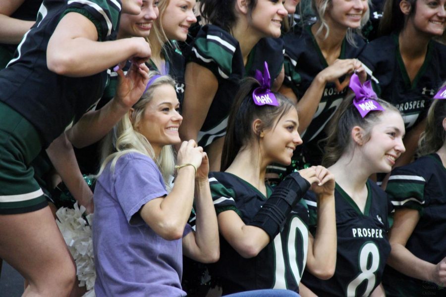 At+the+Homecoming+pep+rally+Friday%2C+Sept.+24%2C+junior+varsity+cheerleading+coach+Emily+Allen%2C+takes+a+picture+with+the+cheerleaders.+The+junior+varsity+cheer+team+has+students+in+grades+sophomore+through+senior+year.+%E2%80%9CTeam+is+respect%2C+collaboration%2C+encouragement+and+support%2C%E2%80%9D+Allen+said.+%E2%80%9CIt+doesn%E2%80%99t+have+to+be+that+everyone+is+best+friends%2C+but+we+all+have+to+learn+to+respect+and+collaborate+with+each+other.%E2%80%9D