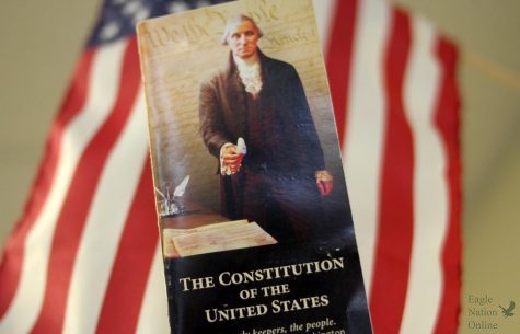 With the American flag in the background, a pocket copy of the U.S. Constitution is held high. Constitution Day is Sept. 17. Constitution day marks the start of Freedom Week. 