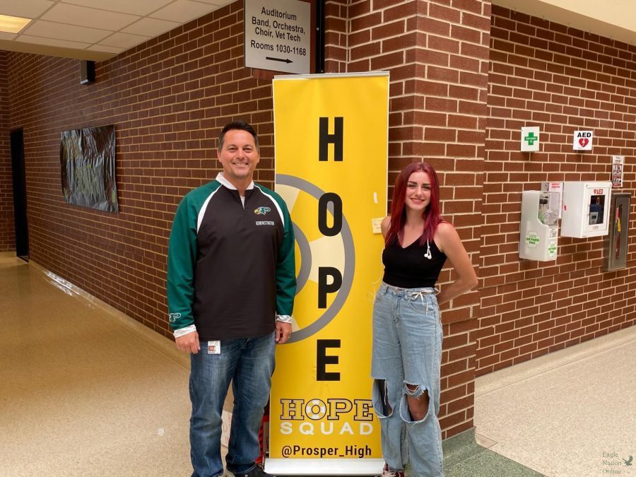 Standing in front of a Hope Squad banner, principal John Burdett and senior Caitlyn Kennedy pose for a picture. In the podcast series titled CK-1, Burdett and Kennedy talk about upcoming events and impactful initiatives the school is taking to include students and improve the community. Burdett and Kennedy plan on producing more podcasts over the school year, discussing important topics such as mental health awareness, inclusion and student-school relationships.  