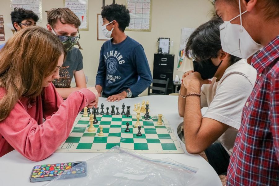 As+freshmen+Niteshwar+Dhillon+and+Dallin+Hansen+watch%2C+junior+Quincy+Lambert+protects+her+king+from+junior+Lakshya+Khurmi%E2%80%99s+queen+in+a+high+intensity+game+of+chess.+Lambert+would+go+on+to+turn+a+losing+game+into+a+winning+game+and+secure+a+victory+against+Khurmi.+%E2%80%9CI+definitely+learned+that+chess+is+not+an+easy+game%2C%E2%80%9D+Khurmi+said.+%E2%80%9CIt+is+not+a+simple+game%2C+and+Quincy+is+very+good+at+it.%E2%80%9D