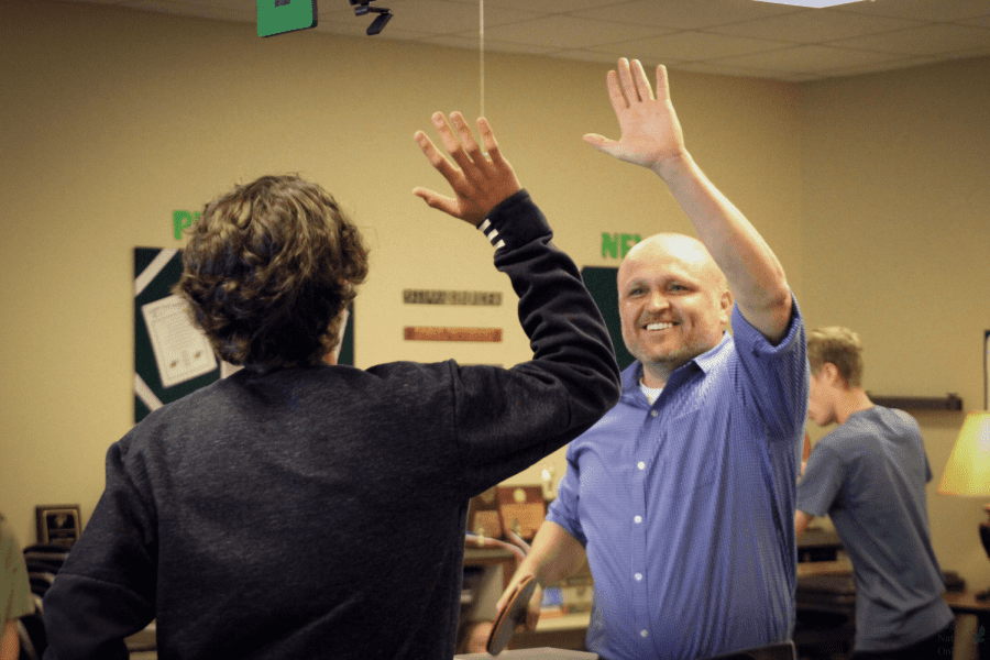 Paddle in hand, math teacher Thomas Gomez reaches for a high-five after a ping pong match against Christopher Max Miller. Gomez, who began playing ping pong at an early age, founded the Prosper High School Ping Pong Club in 2015. The club provides many students with the opportunity to make new friends, develop their skills in the sport and have an after school activity to look forward to each week. 