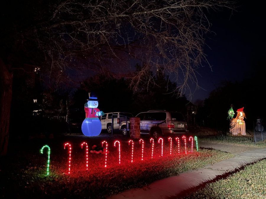 Lighting up, candy canes sit in a houses front yard. The yard also features a blow-up snowman. Houses have shown their holiday lights the whole month of December.