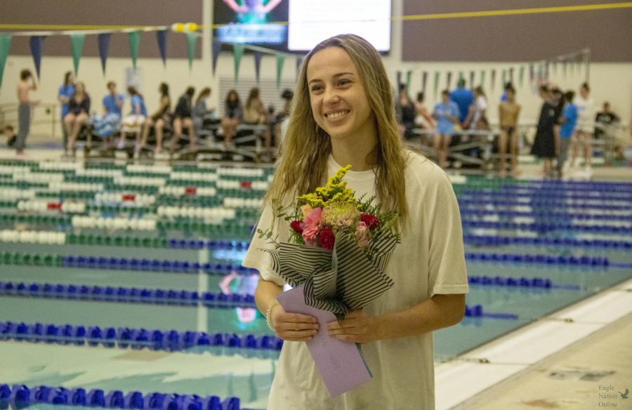 Walking+beside+the+pool%2C+senior+Amanda+Thrasher+carries+her+flowers+after+being+honored+at+the+swim-and-dive+senior+night.+Thrasher+swims+on+the+varsity+team.+The+teams+held+their+senior+night+before+their+meet+Wednesday%2C+Jan.+13%2C+at+the+districts+natatorium.