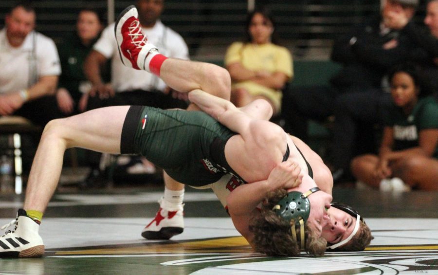 Trying to avoid getting pinned on his back, junior Mason Gordon holds a bridge. In wrestling, opponents can pin the other by holding their back on the mat with any part of both shoulders or shoulder blades making contact with the mat for two seconds. Gordon lost his match.