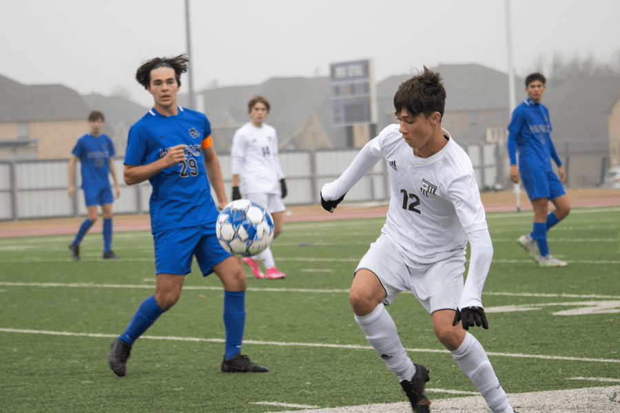 Keeping an eye on the ball, junior Joan Planas steps toward it. This is his first year on varsity. The Eagles won their second game of the tournament against Thomas Jefferson 7-2.