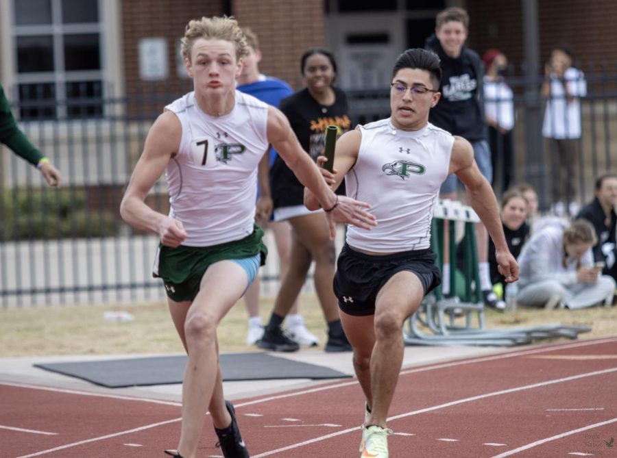 Competing in the junior varsity 4x100 relay, freshman Matthew Thomason receives the baton from sophomore Bo Mongaras. Mongaras also plays football in addition to running track. The team placed first in this event.