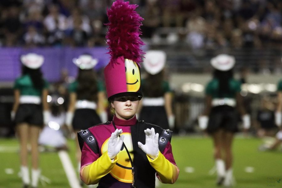 Hands+raised%2C+senior+Emily+Cox+begins+to+direct+the+Mighty+Eagle+Band.+Cox+has+been+a+drum+major+for+two+years%2C+and+was+appointed+as+head+drum+major+her+senior+year.+%E2%80%9CI+remember+cutting+off+the+fourth+and+final+part+of+the+show+after+our+first+full+run+of+the+show+for+the+2021-2022+season%2C+and+being+absolutely+blown+away+by+what+I+had+just+heard%2Fconducted%2C%E2%80%9D+Cox+said.+I+knew+at+that+point+that+that+year+was+going+to+be+a+good+one.