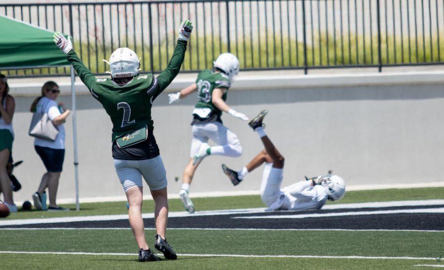 Hands in the air, junior Carson McClendon celebrates with a no fly zone hand signal. This means that a defensive back was able to break up a pass. McClendon plays as a safety. 