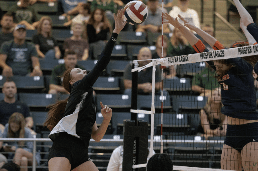 In the air, senior Ella Chaney tips the ball over the net. Chaney committed to the University of Lousiana to play volleyball. The game was played Tuesday, Aug. 16 at Prosper High School Arena.