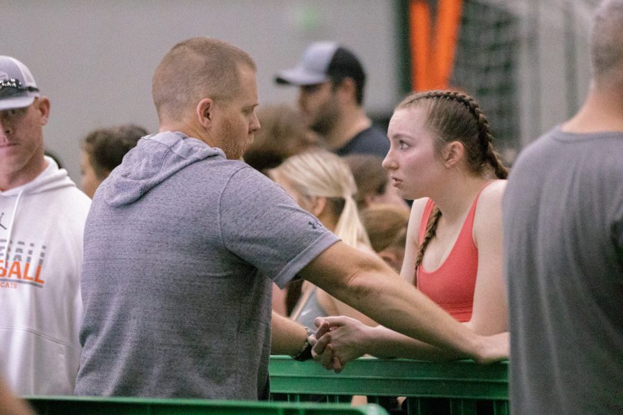 As she holds eye contact on the event, senior Evelyn Grace Pecory listens to advice from head coach Brian Thompson. Pecory placed seventh in the 132-pound-weight class. The girls competed Thursday, Jan. 19 at 5 p.m.